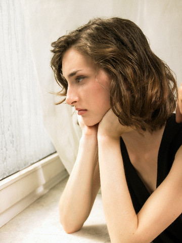 Brunette Young Woman Looking out of Window