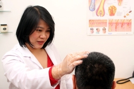 Hair loss specialist examining man's scalp